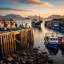 
        Create a visually captivating cover image which encompasses Nestled on the northwest coast, this charming location offers breathtaking views of the surrounding landscapes and is a gateway to the stunning isles. Its bustling harbor is renowned for fresh seafood, creating a culinary paradise for visitors. Enjoy serene walks along the coast and immerse yourself in the calming beauty of this hidden gem..
        Highlight the central location of Mallaig. Focus on iconic landmarks, hidden gems, and the unique atmosphere of the location as described. Depict the image during spring.