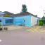 The image depicts the exterior of a building. The composition is acceptable but could be improved. The lighting is adequate, but the overall image appears somewhat soft and lacks fine detail. The colors appear accurate. The building is in focus. The photograph is fairly photo-realistic. The zebra crossing looks amateurish and detracts from the overall impression. Composition/25 - Well-composed, but some elements are unnecessary, 15 points. Well-lit/15 - Good, but nothing special, 10 points. Sharp/20 - Adequate, but not sharp, 13 points. Color-accurate/10 - Seems accurate, 8 points. Photo-realistic/20 - It's a photo, 15 points. Key elements in focus/10 - Yes, 7 points.