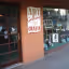 The image shows the exterior of an art gallery and crafts store. The composition is somewhat lacking, as the focus is not entirely clear and the angle is slightly awkward. The lighting appears adequate, but not exceptional, and the sharpness is not ideal, resulting in a slightly blurry image. Color accuracy seems reasonable. The key elements, such as the sign and window display, are somewhat in focus, but not perfectly. Overall, the image is acceptable but could be improved in terms of composition, sharpness, and focus. It's not particularly photo-realistic due to the lack of sharpness and dynamic range.