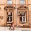 The image depicts the exterior of a museum. It is reasonably well-composed, with the building as the primary subject. The lighting is adequate, though somewhat flat. Sharpness is acceptable, but not exceptional. Color accuracy appears good. The image is reasonably photo-realistic. The key elements, such as the museum entrance and signage, are in focus. The presence of the advertisement sign is acceptable. Overall, the image is of decent quality, but could benefit from improved sharpness and more dynamic lighting.